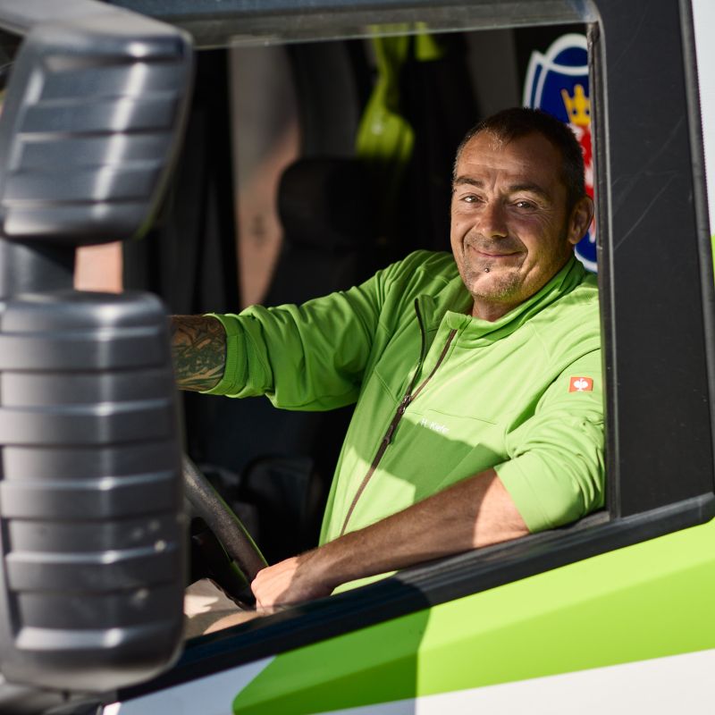 Mitarbeiter Harald Kiefer im Fahrerhaus eines Baustellenfahrzeugs