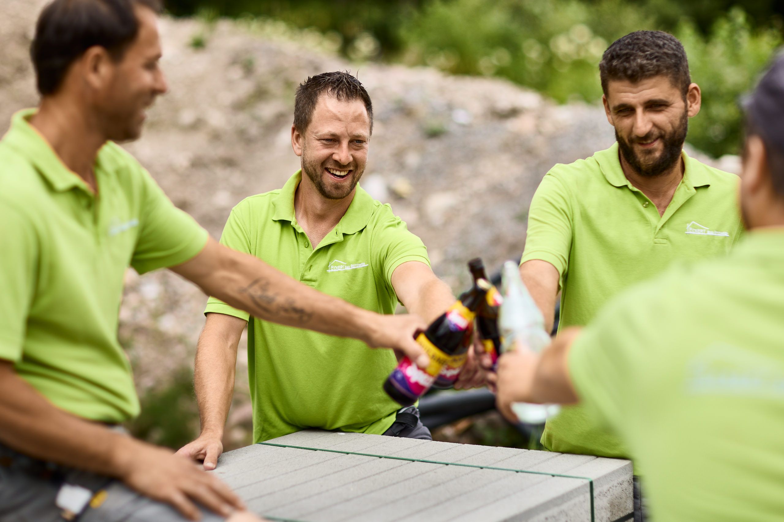 Mitarbeitende der Firma Eckert stoßen mit einem Softdrink auf einer Baustelle an